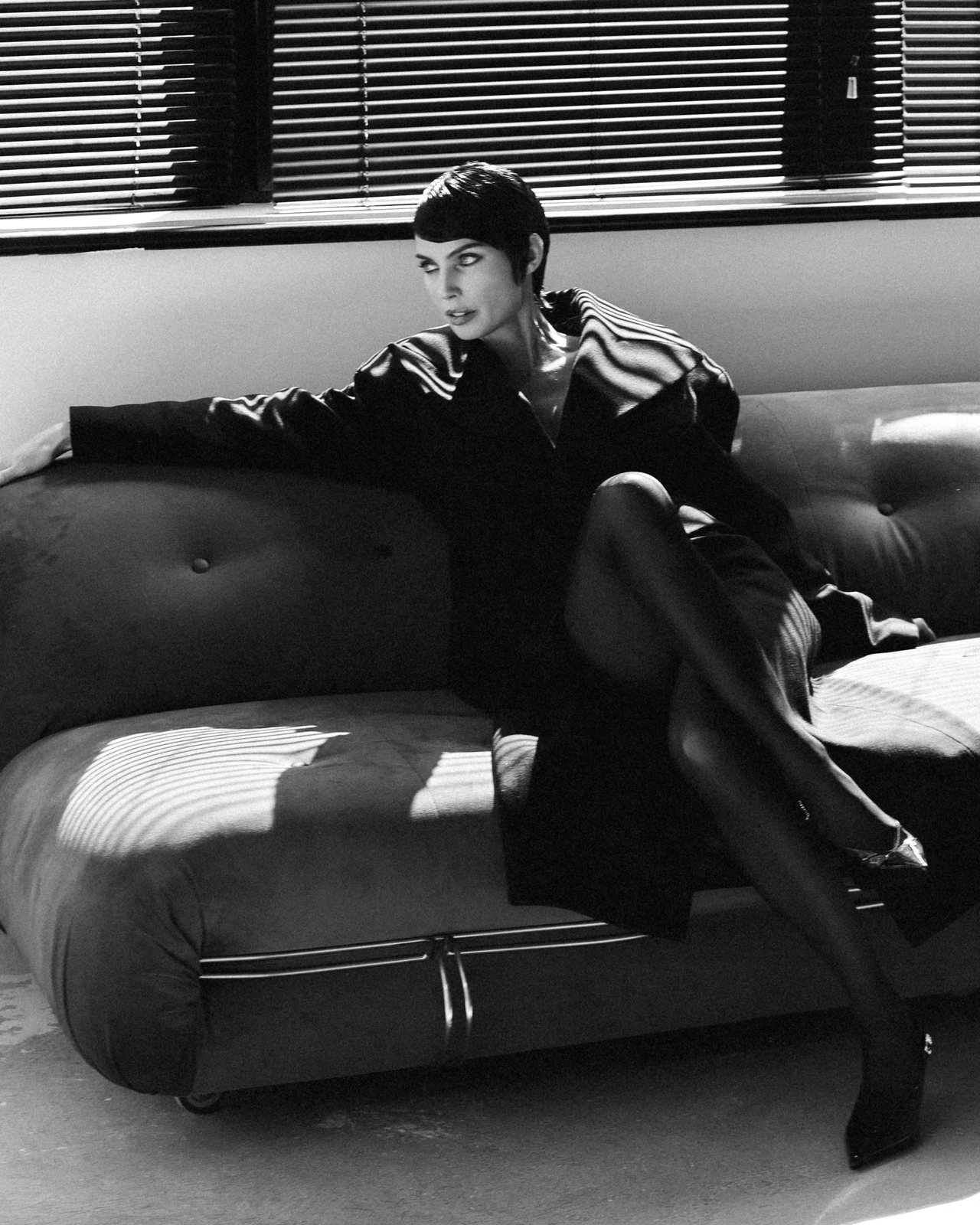 Natalia Boykova seated, window blinds