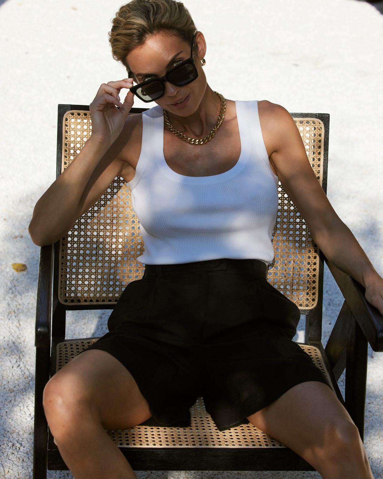 Natalia Boykova seated outdoors, white vest and black shorts