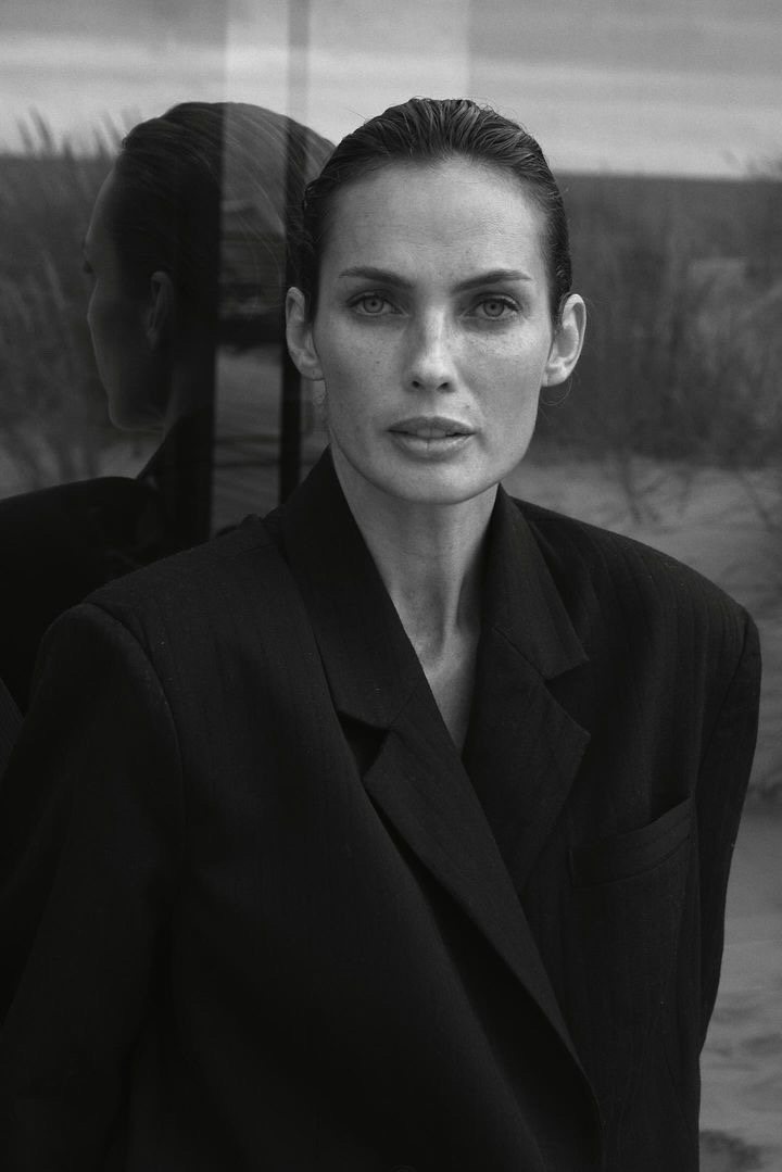 Natalia Boykova in a black blazer, reflection in glass